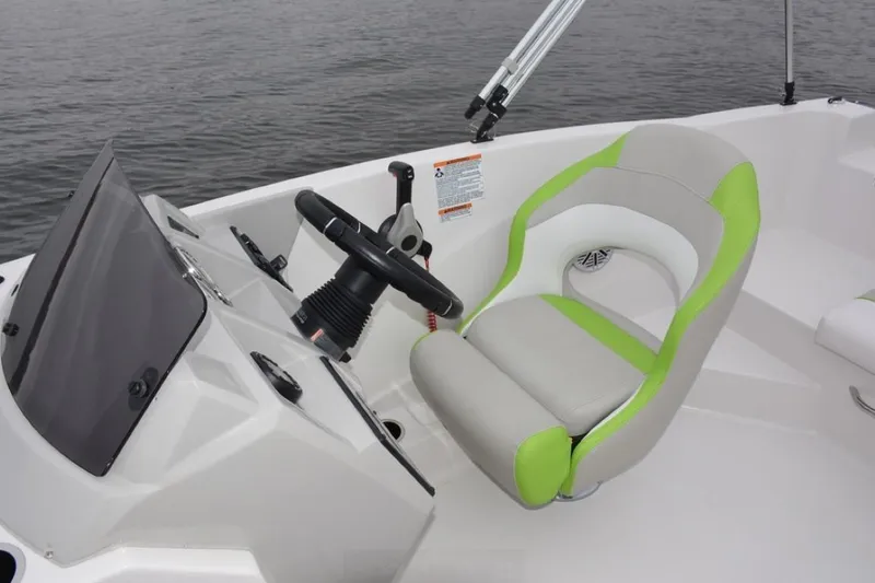 Slide: The Image of 2023 Starcraft 211 SVX boat cockpit with modern steering and green-accented seat. - 9