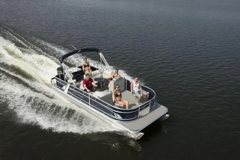 Slide: The Image of 2025 Starcraft 22 LX pontoon boat cruising on a lake with passengers enjoying the ride. - 6