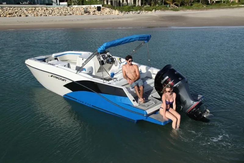 Slide: The Image of 2025 Starcraft 231 SVX boat with two people relaxing on calm water. - 1