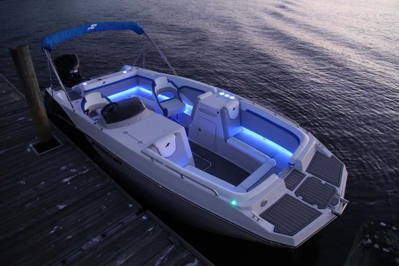 Slide: The Image of 2025 Starcraft 231 SVX boat with blue LED lights docked at sunset. - 4