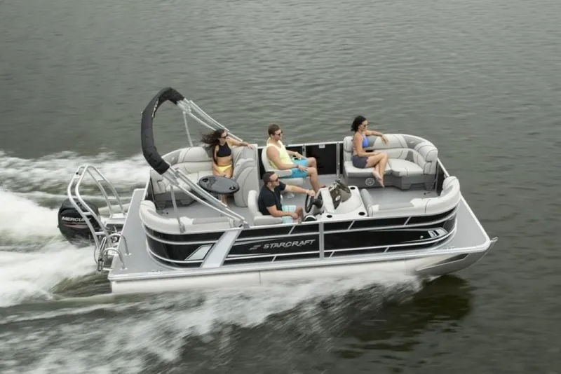 Slide: The Image of 2025 Starcraft EX 24 pontoon boat cruising on a lake with passengers enjoying the ride. - 4
