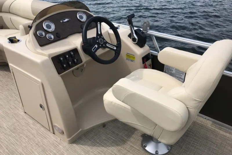 Slide: The Image of Captain's seat and helm of 2025 Starcraft EX 24 boat on water. - 7