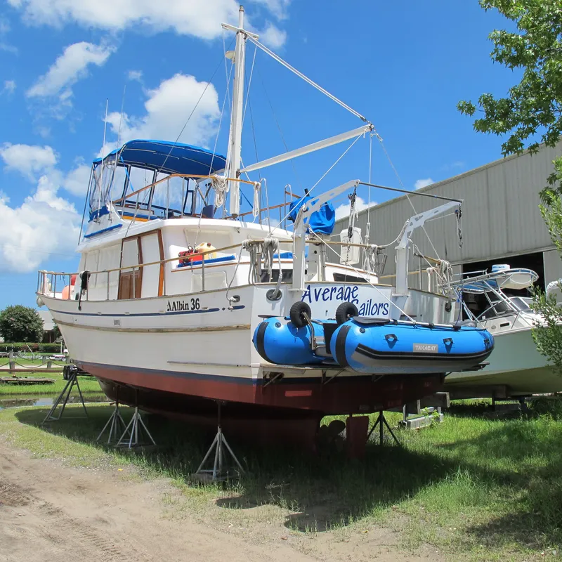 The Image of 1981 Albin 36 boat on stands, blue canopy, clear sky background. - 0
