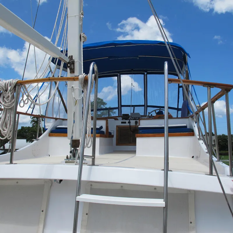 Slide: The Image of 1981 Albin 36 yacht deck with blue canopy and clear sky background. - 10