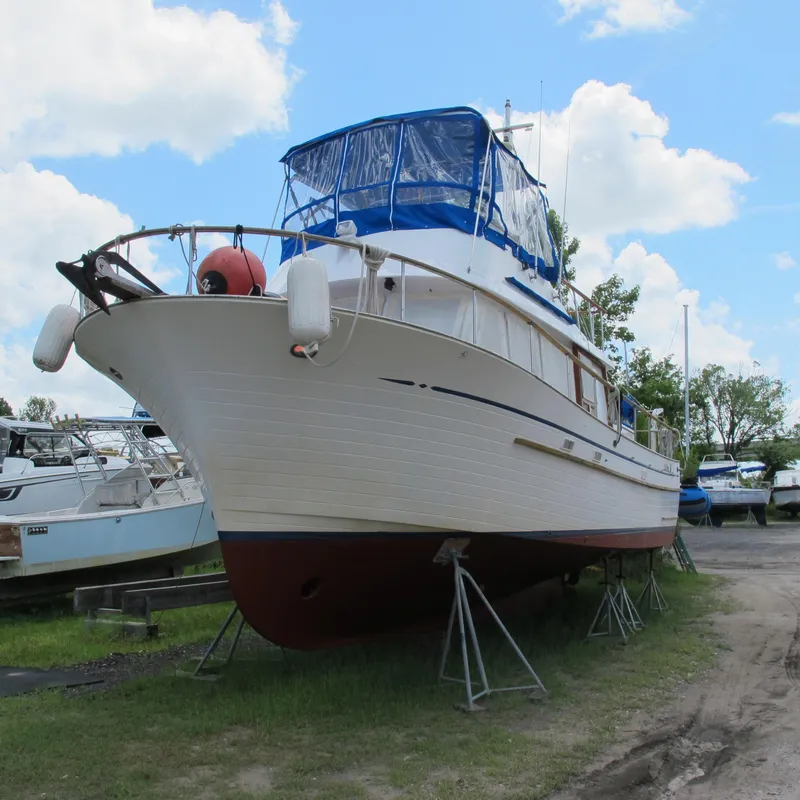 Slide: The Image of 1981 Albin 36 boat on stands, blue canopy, clear sky background. - 2