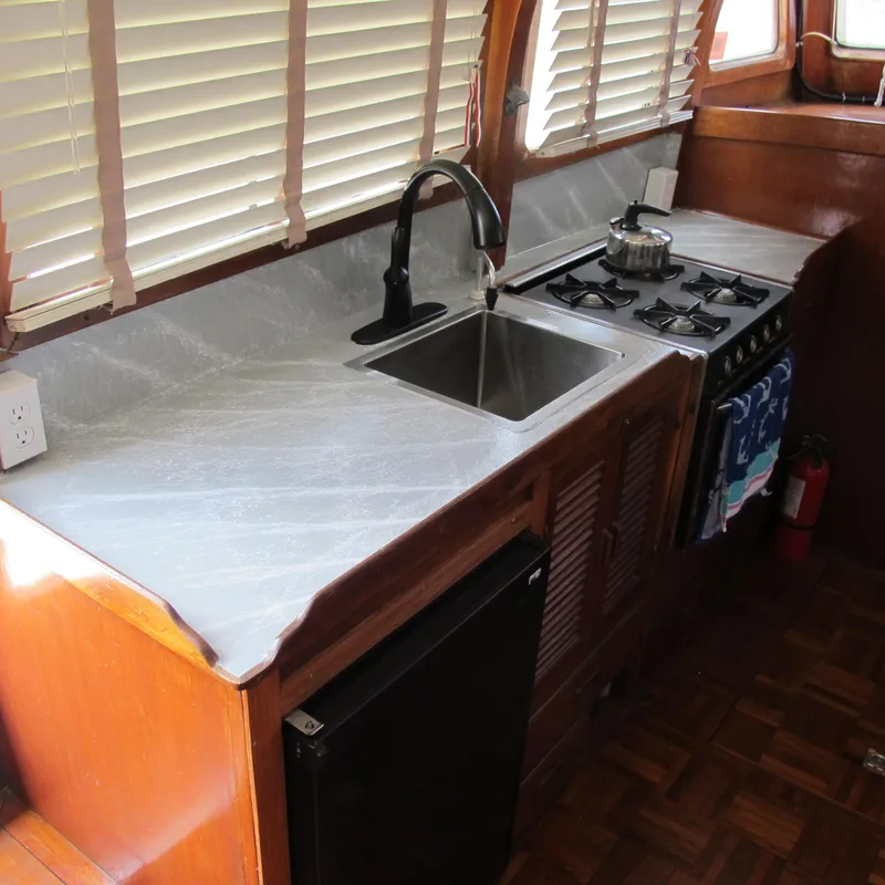 Slide: The Image of 1981 Albin 36 boat kitchen with sink, stove, and wooden cabinetry. - 20