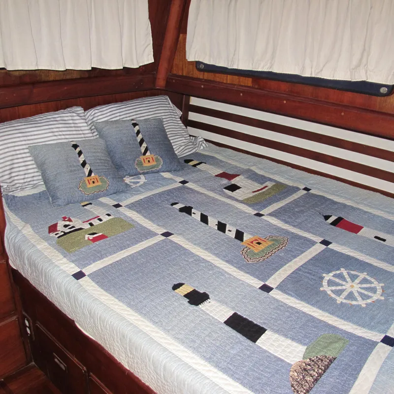 Slide: The Image of Cozy Albin 36 boat cabin with nautical-themed bedding, featuring lighthouses and ship wheels. - 27