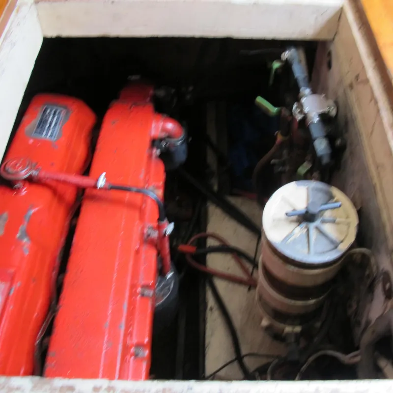 Slide: The Image of Engine compartment of a 1981 Albin 36 boat, featuring red engine components. - 36