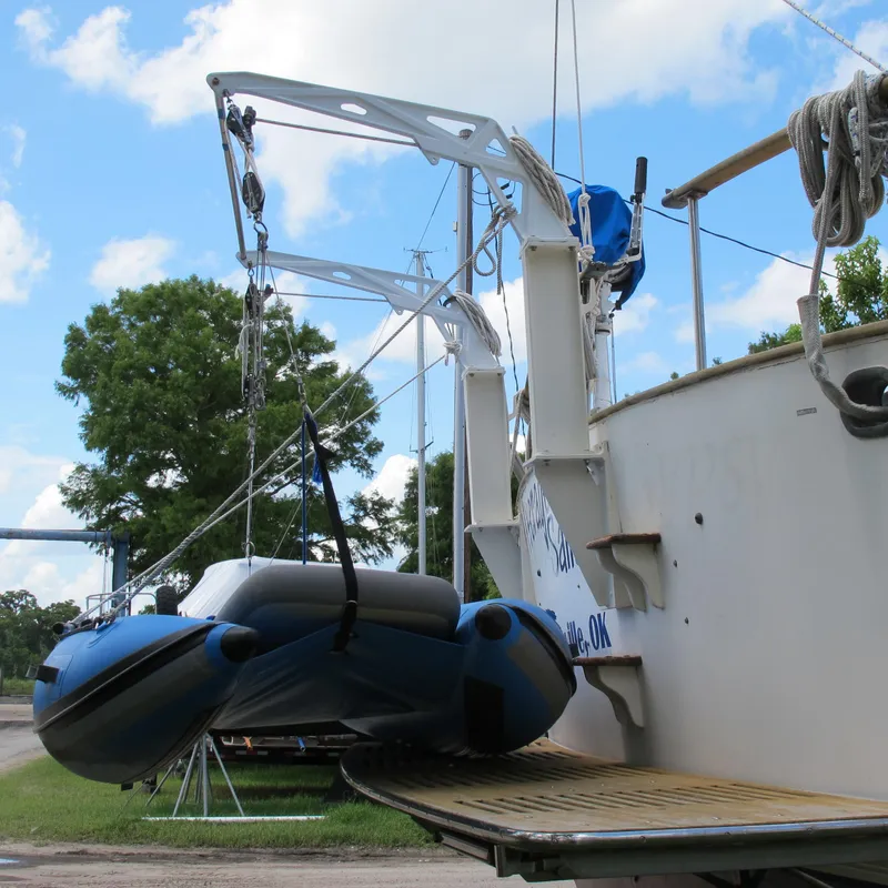 Slide: The Image of 1981 Albin 36 boat with dinghy on davits, docked outdoors under blue sky. - 7