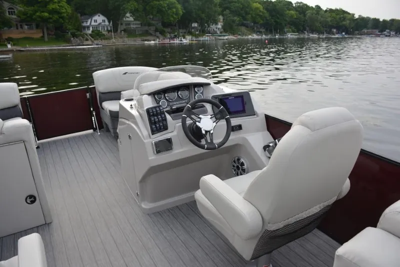 Slide: The Image of 2025 Starcraft SLS 3 boat interior with modern dashboard and steering on a serene lake. - 12