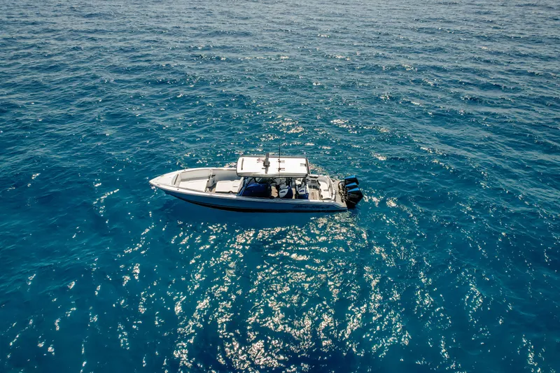 Slide: The Image of 2022 Nor-Tech 390 Center Console boat on clear blue ocean water. - 13