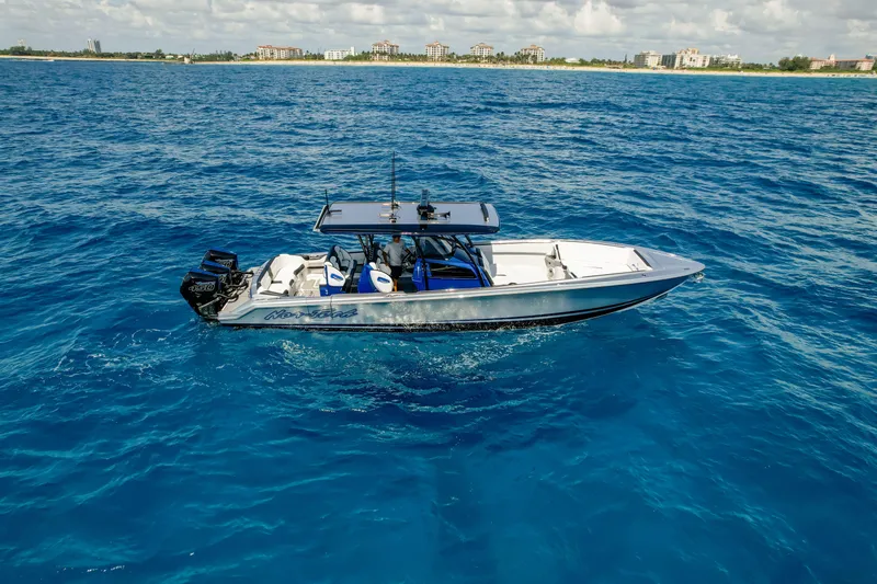 Slide: The Image of 2022 Nor-Tech 390 Center Console boat cruising on clear blue ocean waters. - 14