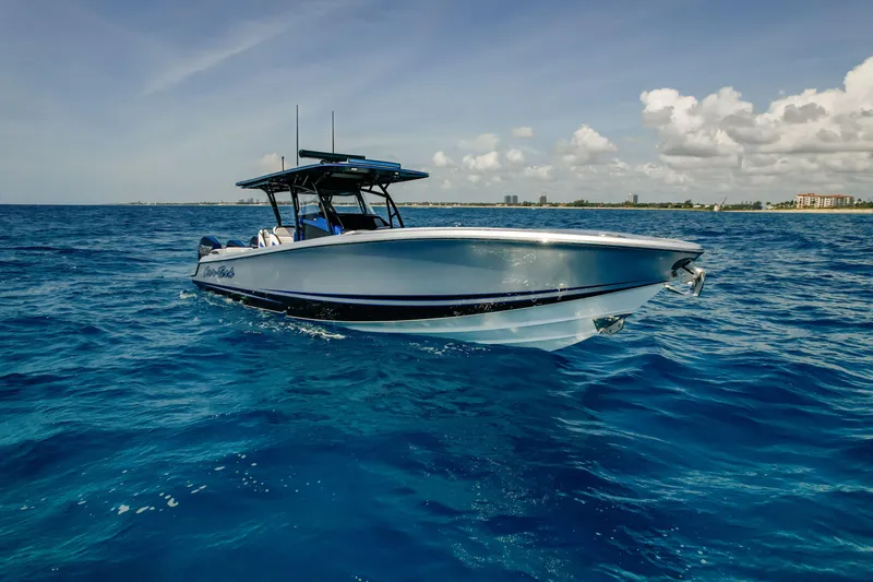 Slide: The Image of 2022 Nor-Tech 390 Center Console boat cruising on open blue ocean under clear sky. - 16