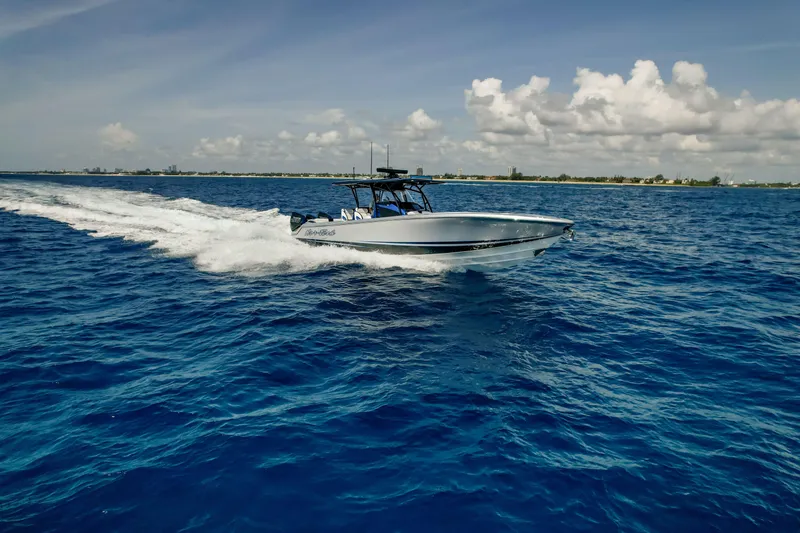 Slide: The Image of 2022 Nor-Tech 390 Center Console boat cruising on open blue ocean under clear sky. - 17