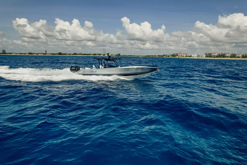 Slide: The Image of 2022 Nor-Tech 390 Center Console cruising on open blue ocean under cloudy sky. - 18