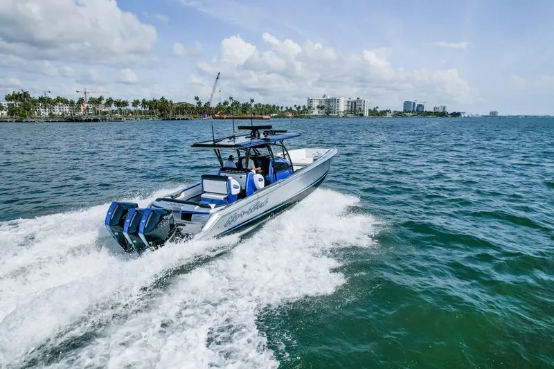 Slide: The Image of 2022 Nor-Tech 390 Center Console boat cruising on open water, cityscape in background. - 19
