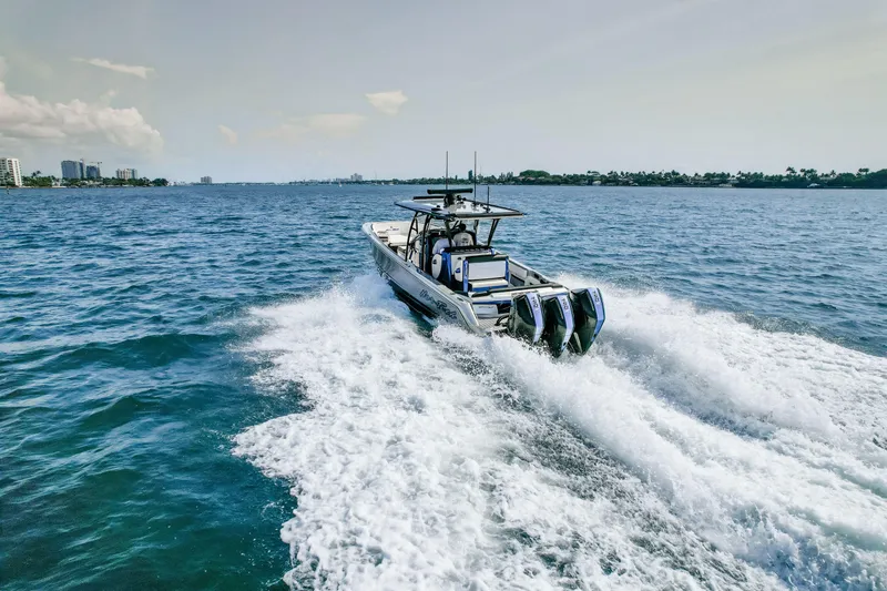 Slide: The Image of 2022 Nor-Tech 390 Center Console boat cruising on open water, creating a wake. - 20