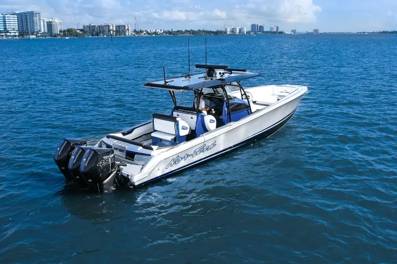 Slide: The Image of 2022 Nor-Tech 390 Center Console boat cruising on blue water near city skyline. - 8