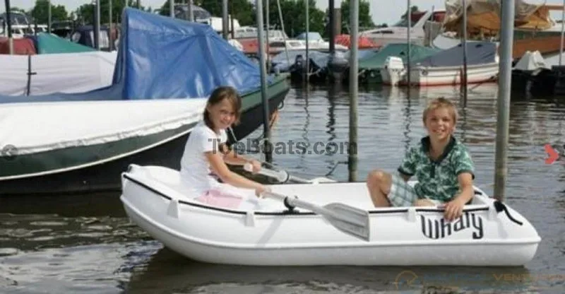 Slide: The Image of Children enjoying a ride in a 2022 Whaly 210 boat at a marina. - 1