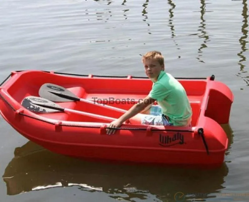 Slide: The Image of A person in a red 2022 Whaly 210 boat on calm water. - 2
