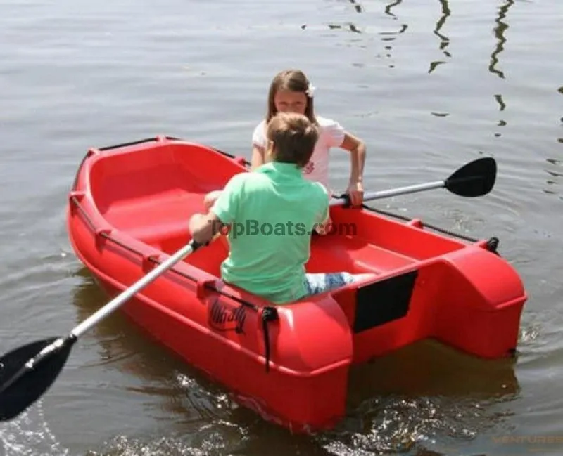 Slide: The Image of Two people rowing a red 2022 Whaly 210 boat on calm water. - 5