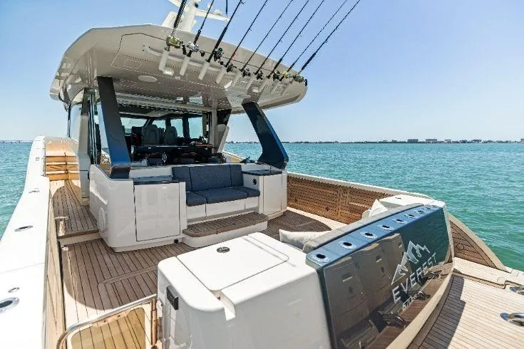 Slide: The Image of 2026 Scout 670 LXS luxury boat with spacious deck and fishing rods on a sunny day. - 14