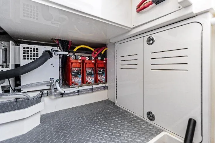 Slide: The Image of 2026 Scout 670 LXS boat battery compartment with red batteries and wiring. - 29
