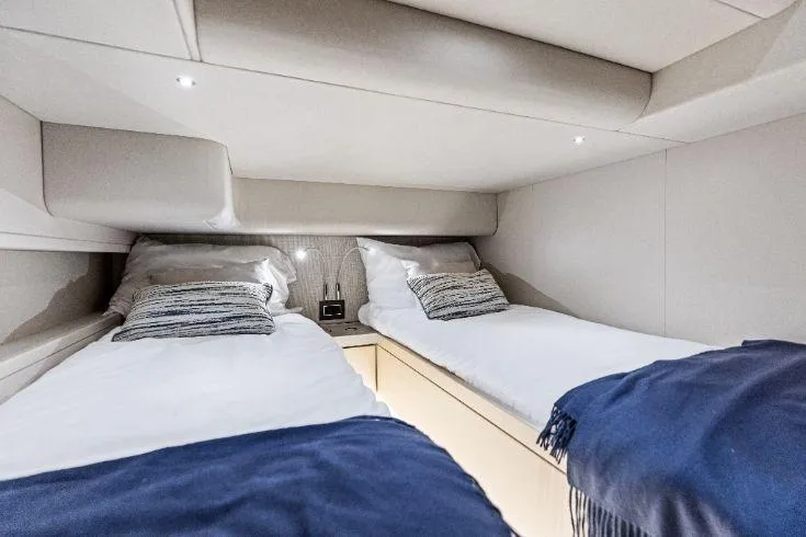 Slide: The Image of 2026 Scout 670 LXS cabin with twin beds, modern design, and cozy bedding. - 55