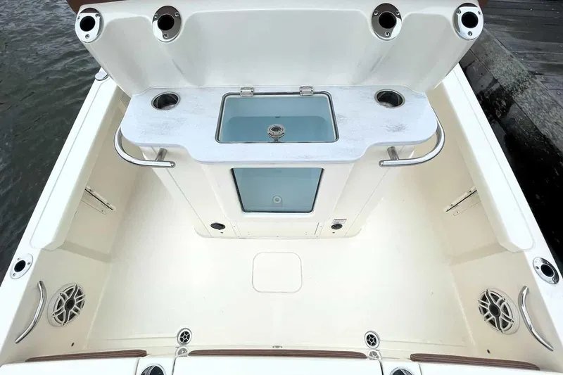 Slide: The Image of 2026 Scout 261 XSS boat storage compartment with open lid and cushioned seating. - 6