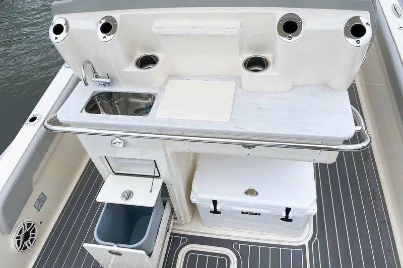 Slide: The Image of Open storage compartment on 2026 Scout 261 XSS boat, containing coiled rope. - 7