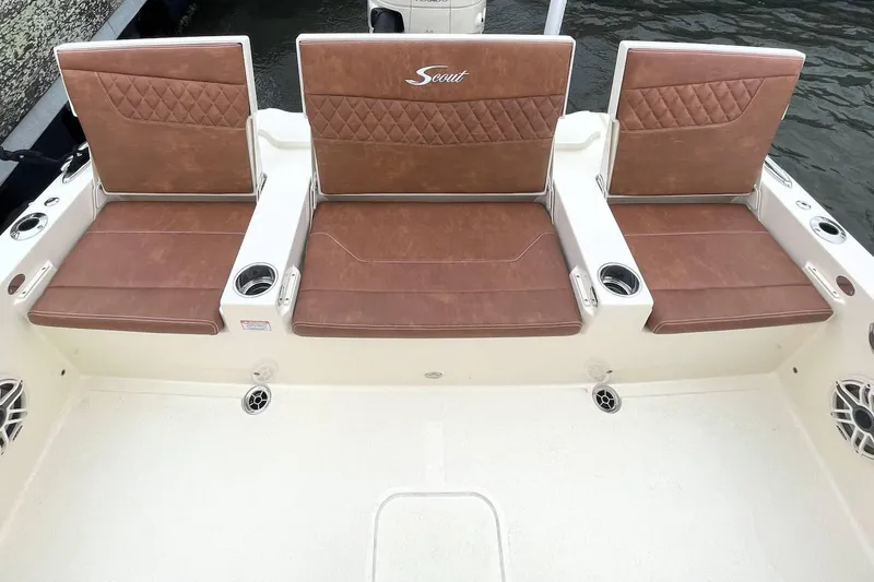 Slide: The Image of Open storage compartment on 2026 Scout 261 XSS boat, featuring speakers and cup holders. - 9