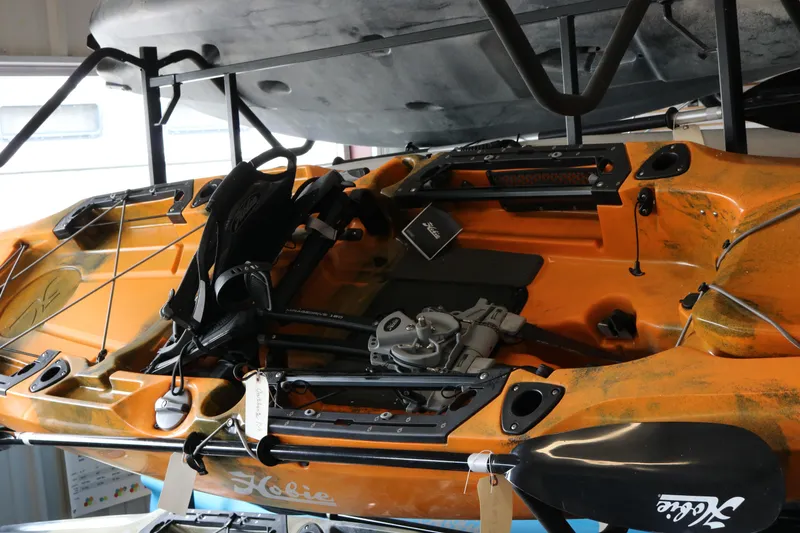 The Image of 2023 Hobie Mirage Outback kayak in storage, showcasing pedal drive system and seating. - 0