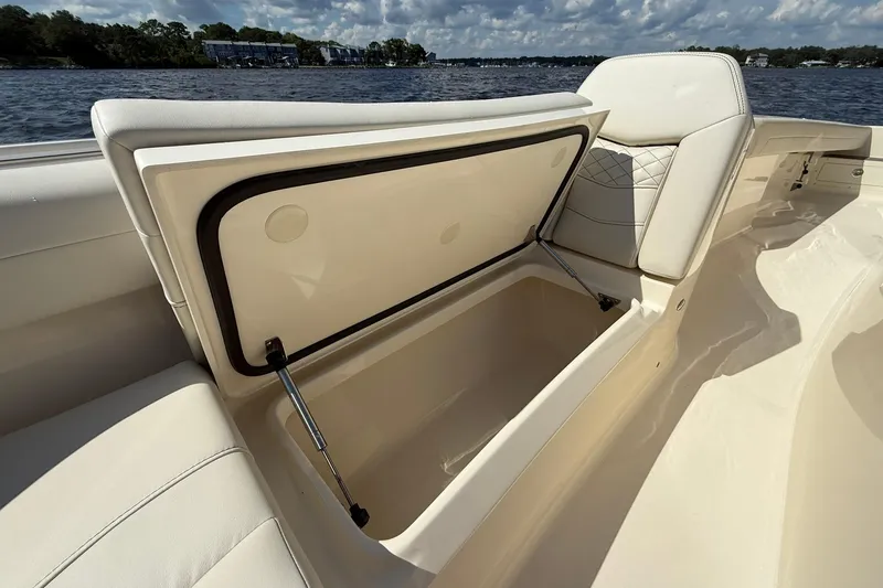 Slide: The Image of 2026 Scout 281 XSS boat with open storage compartment, showcasing luxury seating. - 10