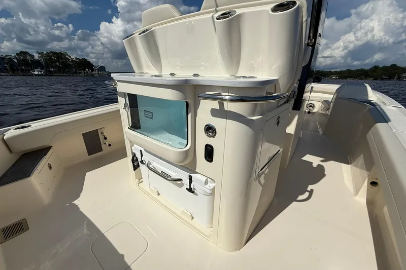 Slide: The Image of 2026 Scout 281 XSS boat interior with storage and seating, on a sunny day. - 22