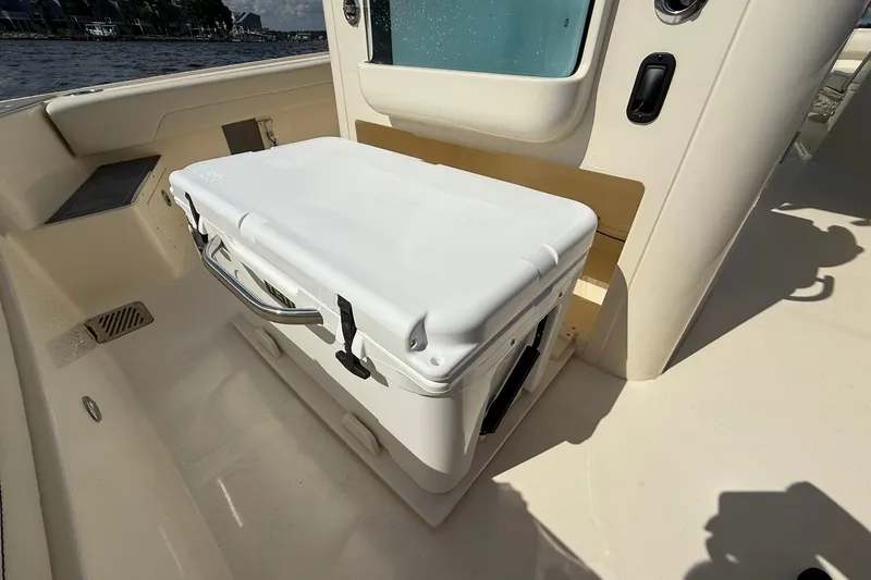 Slide: The Image of 2026 Scout 281 XSS boat interior with a white cooler on deck. - 23