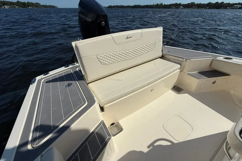 Slide: The Image of 2026 Scout 281 XSS boat interior with cushioned seating and Mercury engine on water. - 24