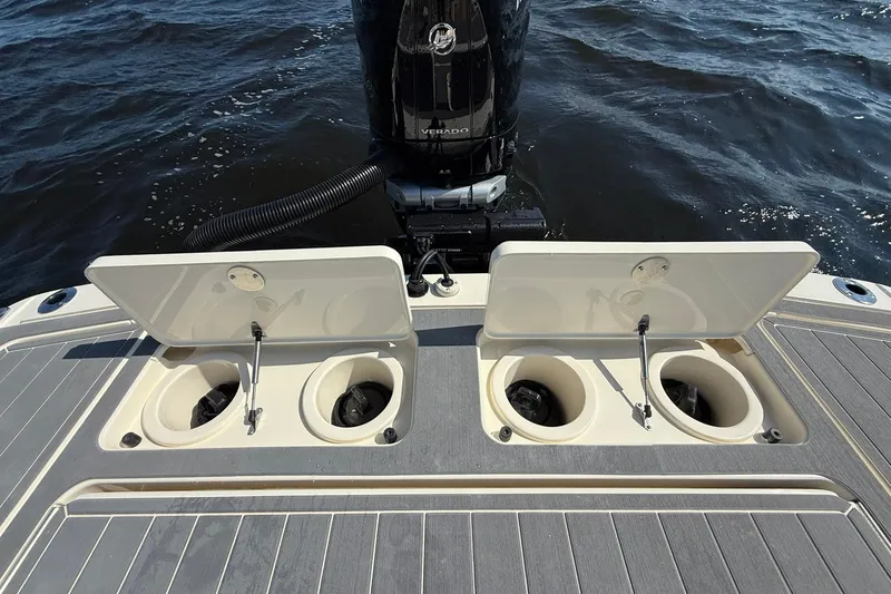 Slide: The Image of 2026 Scout 281 XSS boat with open storage compartments and outboard motor on water. - 28