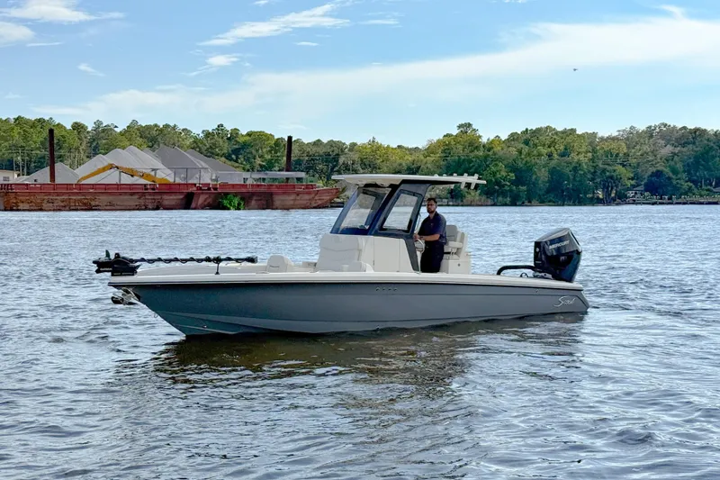 Slide: The Image of 2026 Scout 281 XSS boat on a calm river with trees in the background. - 3
