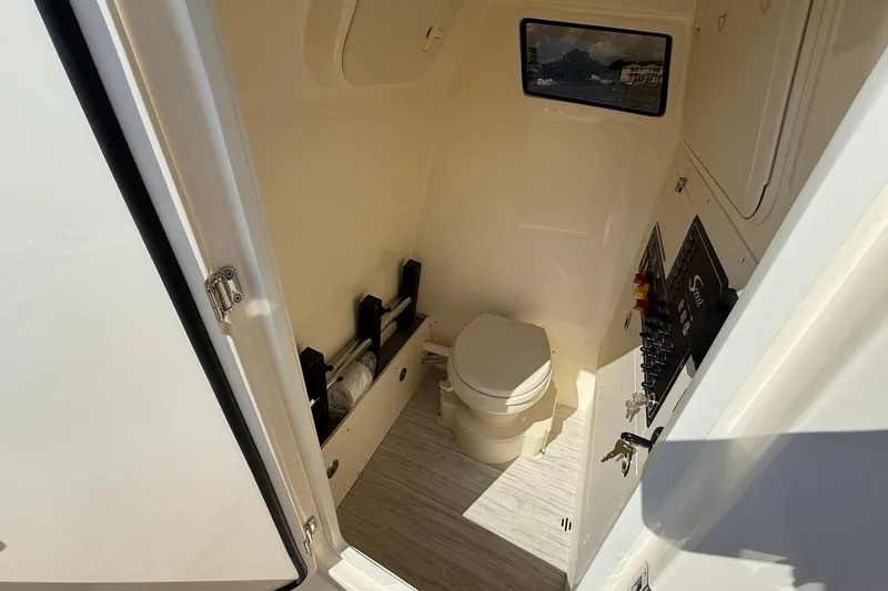 Slide: The Image of 2026 Scout 281 XSS boat interior with compact bathroom and control panel. - 32