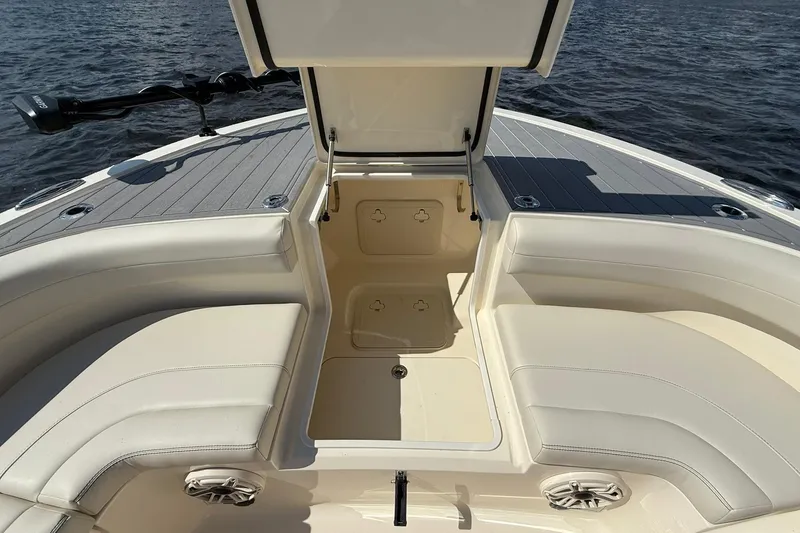 Slide: The Image of 2026 Scout 281 XSS boat interior with open storage compartment and cushioned seating. - 7