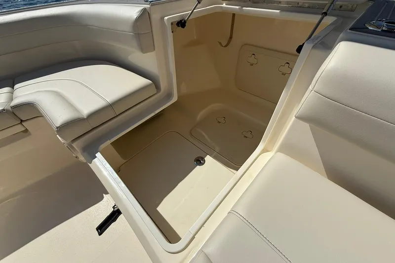 Slide: The Image of 2026 Scout 281 XSS boat interior storage compartment with cushioned seating. - 8