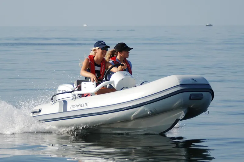 Slide: The Image of 2024 Highfield Classic 310 FCT inflatable boat cruising on calm water. - 1