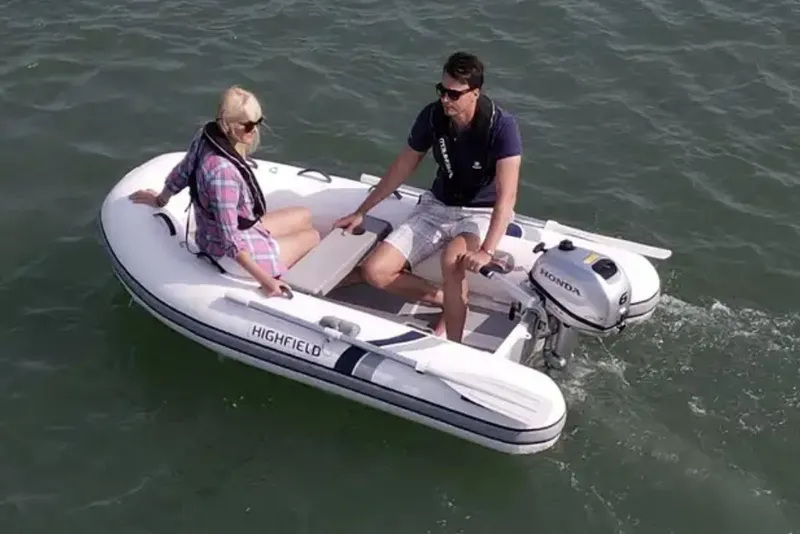 The Image of 2025 Highfield Ultralite 310 inflatable boat with two people on calm water. - 0
