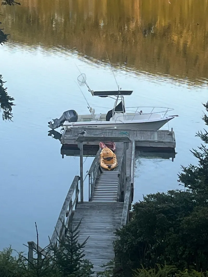 Slide: The Image of 2005 Hydra-Sports Lightning 212 CC boat docked on calm lake with kayak. - 2