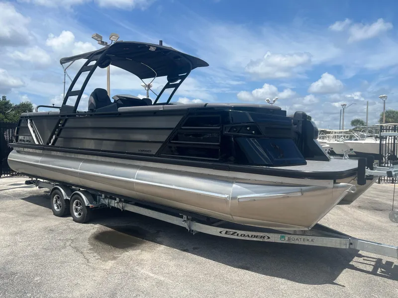 Slide: The Image of 2025 Veranda VX 27 DCRC pontoon boat on trailer under blue sky. - 2