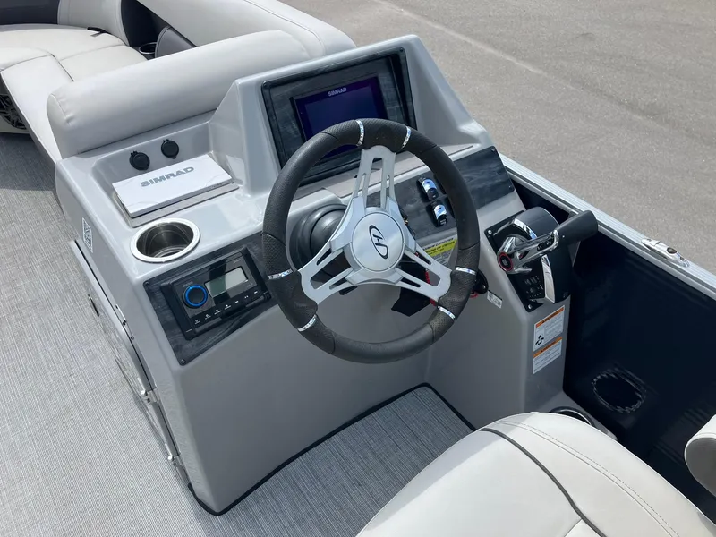 Slide: The Image of 2023 Harris Cruiser 230 boat dashboard with steering wheel and control panel. - 13