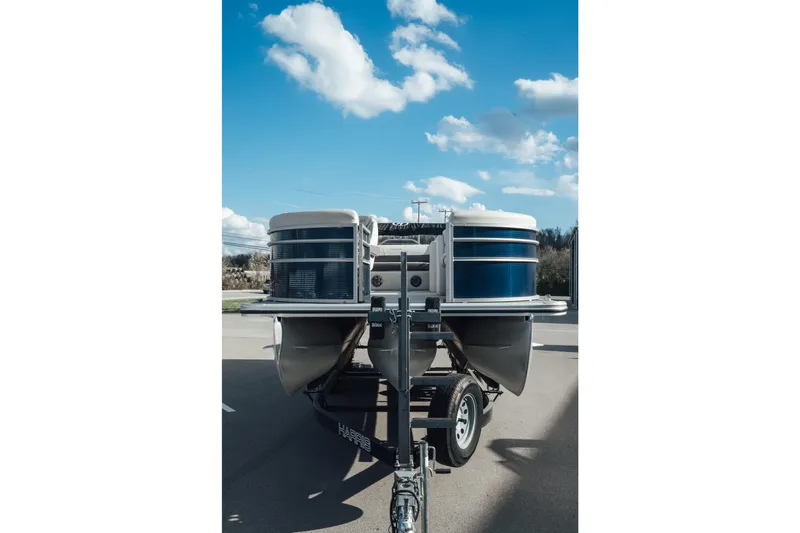 Slide: The Image of 2023 Harris Cruiser 230 pontoon boat on trailer under blue sky. - 19