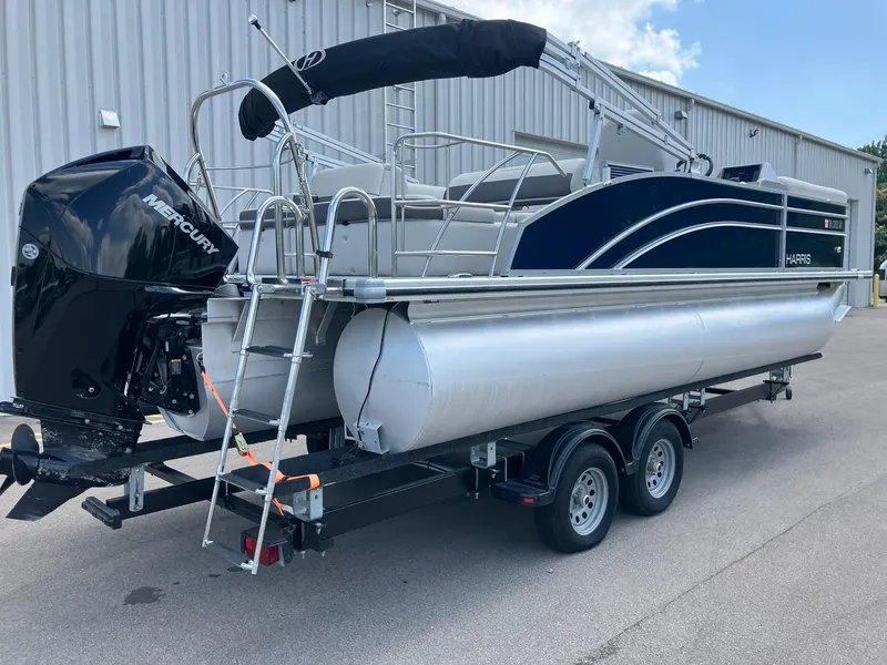 Slide: The Image of 2023 Harris Cruiser 230 pontoon boat on trailer with Mercury outboard motor. - 2