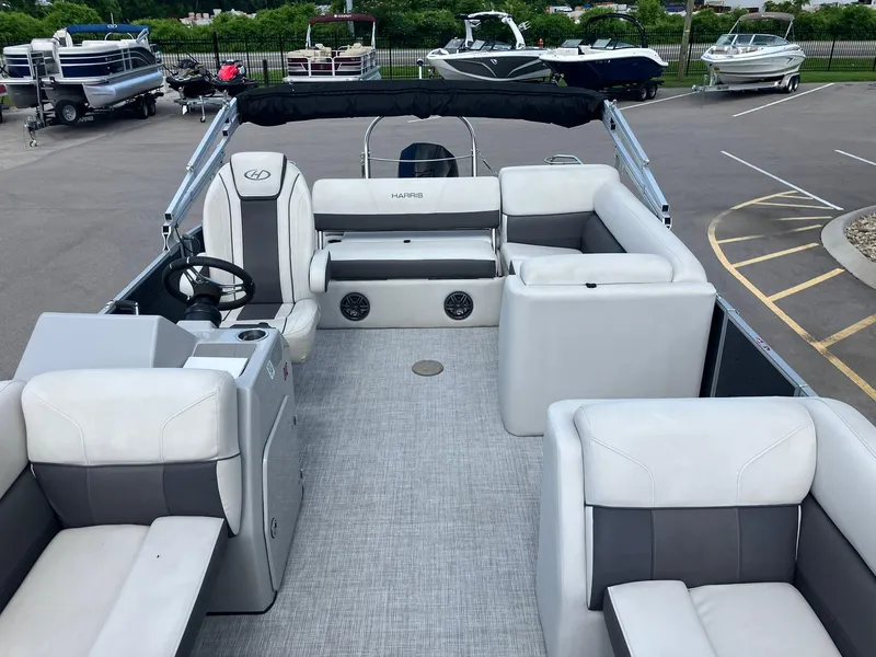 Slide: The Image of 2023 Harris Cruiser 230 pontoon boat with spacious seating and modern design in a parking lot. - 6