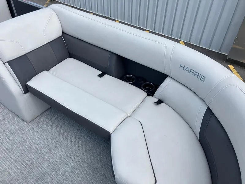 Slide: The Image of 2023 Harris Cruiser 230 boat interior with white and gray seating, cup holders visible. - 8